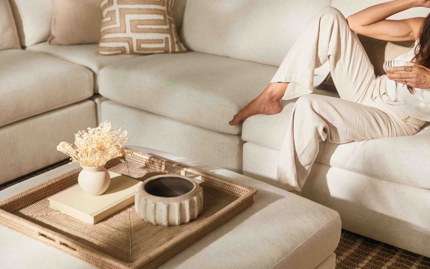 Woman sitting comfortably on beige Beckham BenchMade sofa